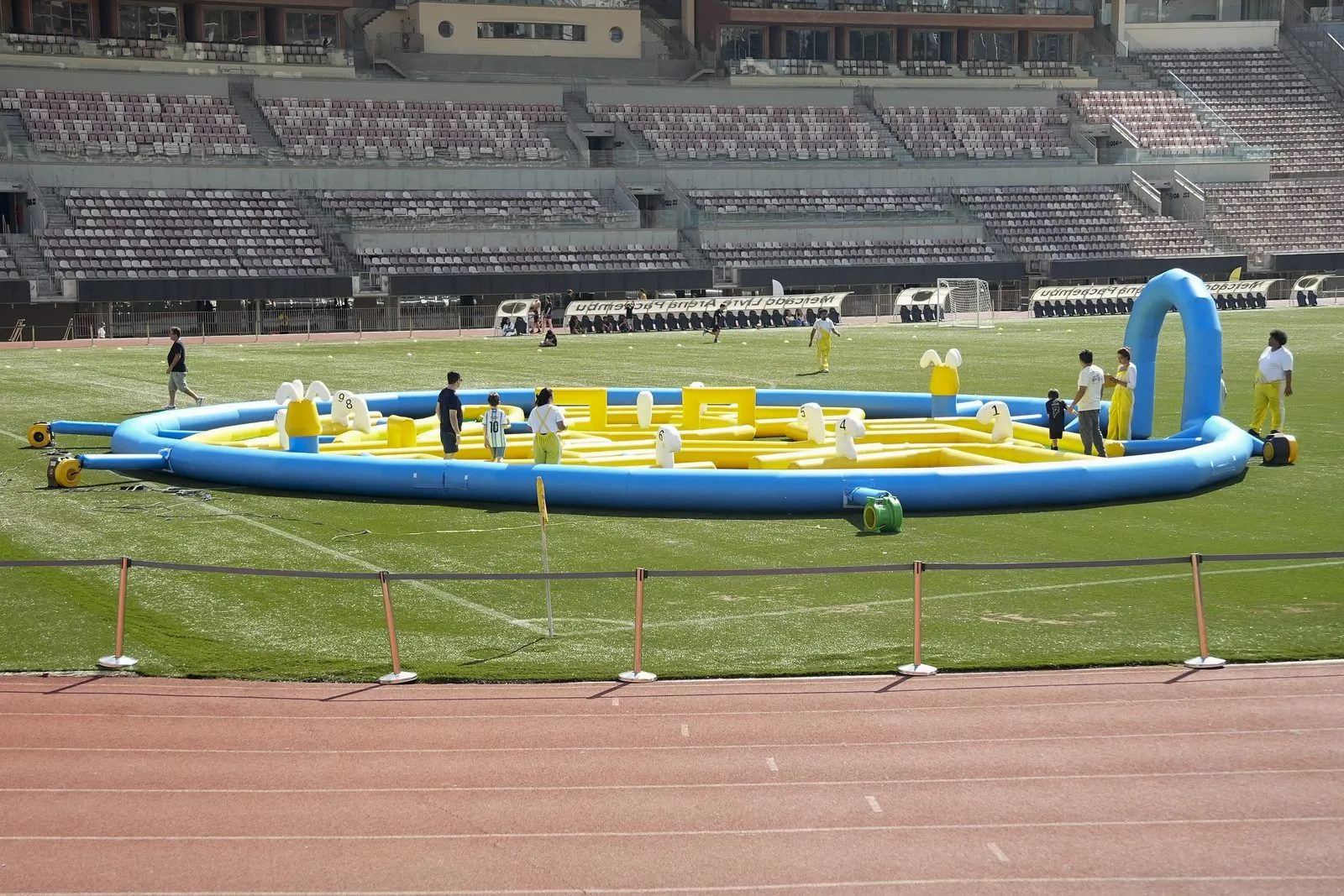 Estrutura inflável montada no gramado de um estádio durante um evento Confra FC
