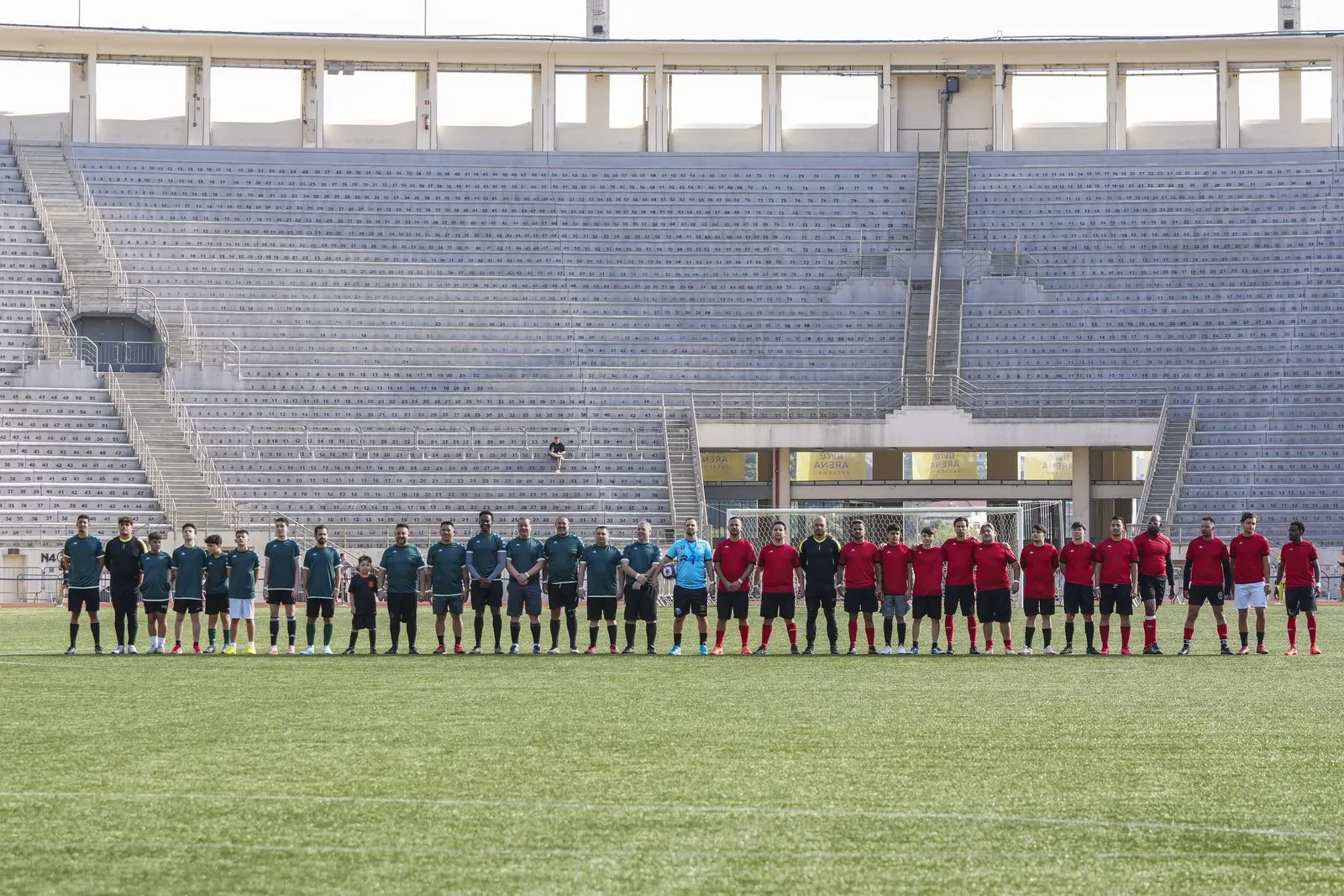 Times perfilados no gramado do estádio antes do início de uma partida do Confra FC